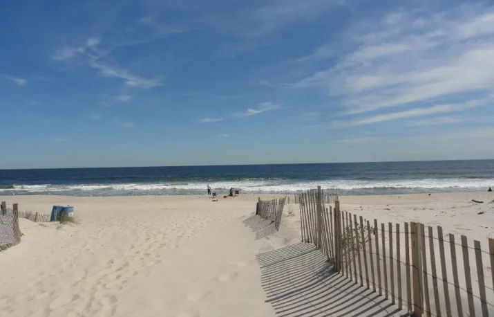 Sunny day at Jenkinson’s Beach with visitors enjoying the sand and ocean in Point Pleasant Beach, NJ
