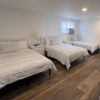 Triple bed suite with queen, full, and twin beds at Driftwood Motel in Point Pleasant Beach, NJ